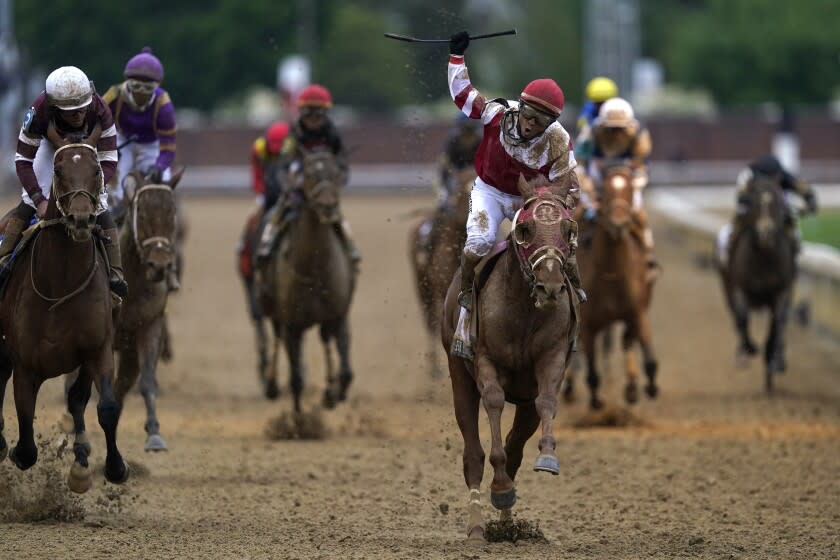 Sonny Leon celebrates after riding Rich Strike past the finish line to win the 148th running.