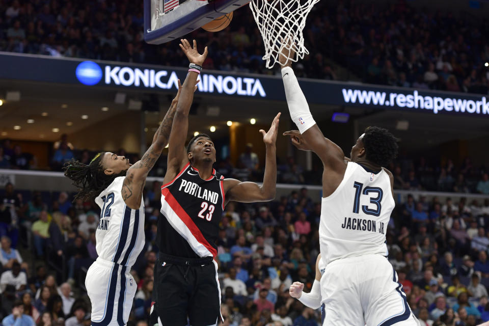 Portland Trail Blazers guard Jeenathan Williams (23) shoots between Memphis Grizzlies guard Ja Morant (12) and forward Jaren Jackson Jr. (13) in the first half of an NBA basketball game Tuesday, April 4, 2023, in Memphis, Tenn. (AP Photo/Brandon Dill)