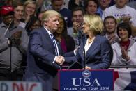 President-elect Donald J. Trump greets Betsy DeVos, his choice for education secretary, during his "USA Thank You Tour" at the DeltaPlex in Walker, Mich., Friday, Dec. 9, 2016. (Cory Morse/The Grand Rapids Press-MLive.com via AP)