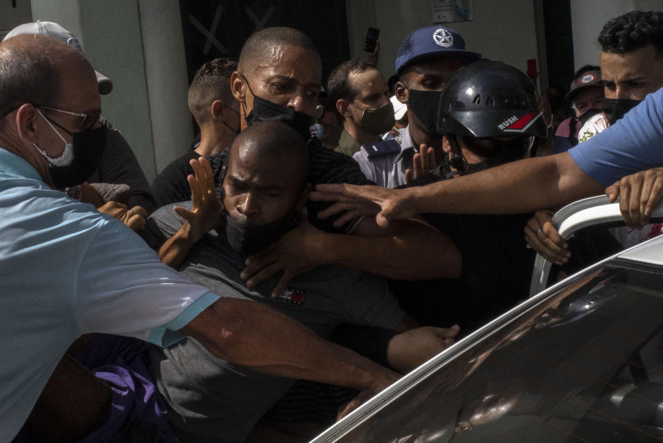 Police detain an anti-government demonstrator during a protest in Havana, Cuba, Sunday July 11, 2021. Hundreds of demonstrators went out to the streets in several cities in Cuba to protest against ongoing food shortages and high prices of foodstuffs, amid the new coronavirus crisis. (AP Photo/Ramon Espinosa)