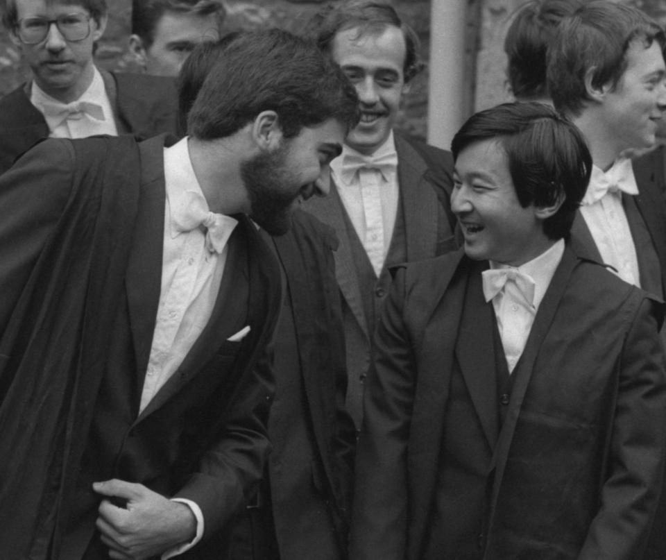 FILE - Japan's Prince Hiro, right, talks with a fellow student at Oxford University when he and other students were welcomed to the university at a matriculation ceremony, on Oct. 15, 1983. Naruhito and the Empress Masako, who studied at Oxford a few years after her husband, wrapped up a weeklong trip to Britain on Friday. Their itinerary combined the glitter and ceremony of a state visit with four days of less formal events that gave the royal couple an opportunity to revisit their personal connections to Britain. (AP Photo/Peter Kemp, File)