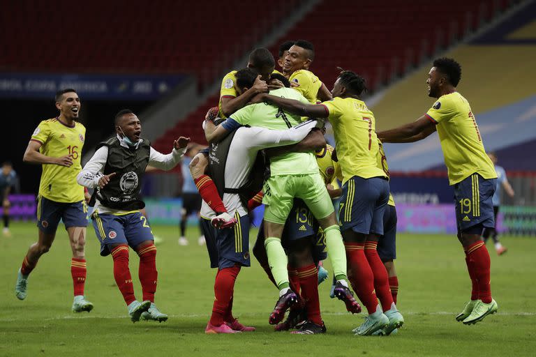 Los futbolistas colombianos abrazan a David Ospina; el arquero atajó dos penales y fue la razón de la clasificación del conjunto colombiano a las semifinales de la Copa América.