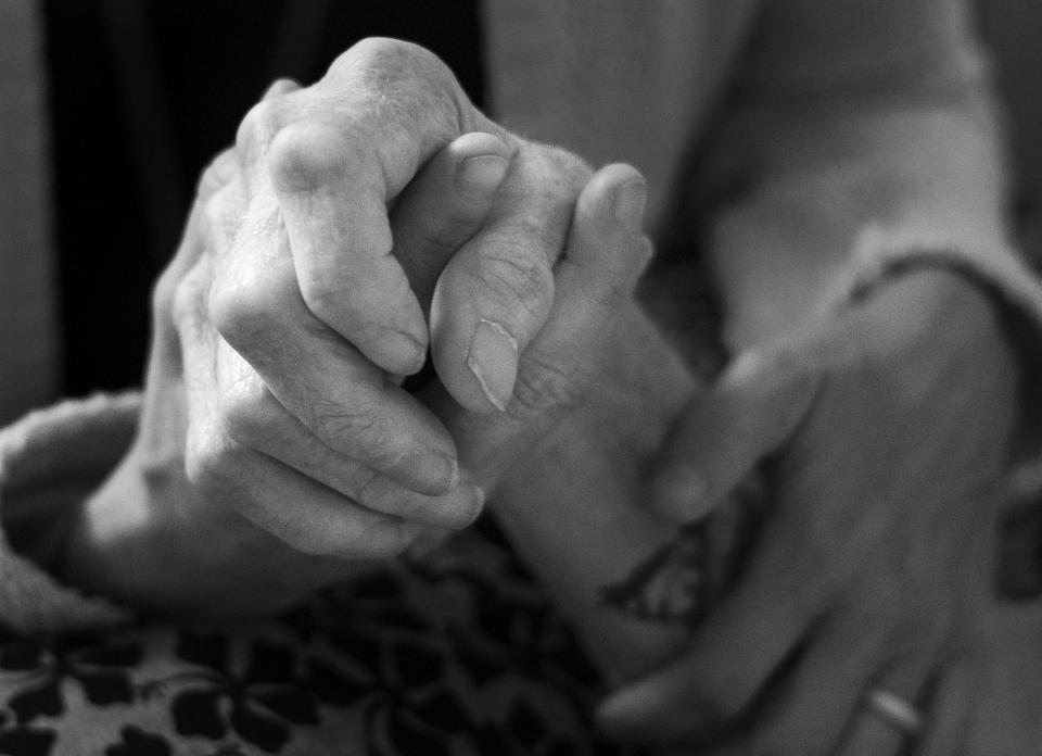 No One Dies Alone volunteer Amy Leininger holds Paul Youngblood’s hand at The INN Between in Salt Lake City on Sunday, Aug. 6, 2023. | Laura Seitz, Deseret News