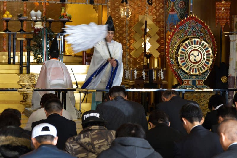 A Shinto priest performs the "Oharai" ritual for office workers during a ceremony at Kanda Myojin shrine in Tokyo on January 4, 2017. On December 15, 1945, U.S. Gen. Douglas MacArthur ordered an end to state Shintoism in Japan, a key belief of which was that the emperor was a divine being. File Photo by Keizo Mori/UPI