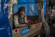 An elderly farmer sits in the back of a tractor trolly as they block a highway in protest against new farm laws at the Delhi-Uttar Pradesh state border, outskirts of New Delhi, India, Wednesday, Jan. 20, 2021. Farmers have been blockading highways connecting New Delhi to northern India for nearly seven weeks against new farm laws, obstructing transportation and dealing a blow to manufacturing and businesses in the north. Farmers fear the government will stop buying grain at minimum guaranteed prices and that corporations will then push prices down under the new laws. (AP Photo/Altaf Qadri)