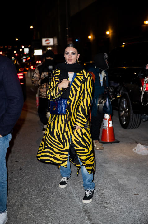 NEW YORK, NEW YORK - FEBRUARY 15: Emily Ratajkowski seen wearing blue bag, yellow black coat with zebra print, denim jeans, vans outside Michael Kors during New York Fashion Week on February 15, 2022 in New York City. (Photo by Christian Vierig/Getty Images)