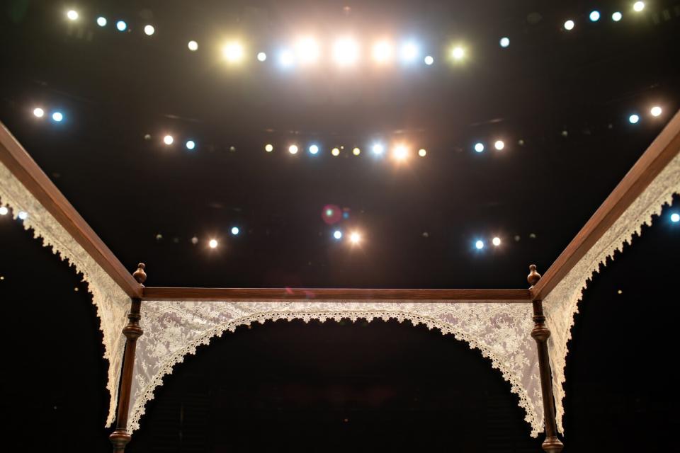 Stage light illuminates a lace-draped, four-poster bed on the set of "Slave Play."