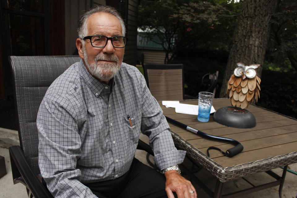 Gordon Haberman sits for a photo with his two dogs, Tuesday, Sept. 6, 2022 in West Bend, Wis. His daughter Andrea Haberman died in the Sept. 11, 2001 attacks in New York. The self-professed architect of that day's destruction, Khalid Sheik Mohammed, was captured in 2003 and still has not stood trial. Several who spoke to The Associated Press, including Haberman, have not given up hope that he might still be held accountable. (AP Photo/Carrie Antlfinger)