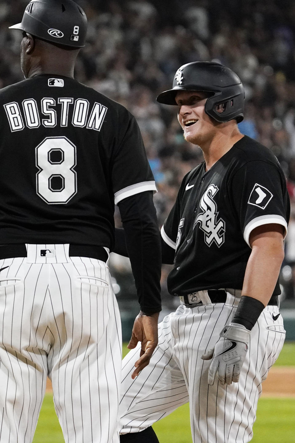 Chicago White Sox's Andrew Vaughn, right, talks with first base coach Daryl Boston after hitting a two-run single during the seventh inning of a baseball game against the Detroit Tigers in Chicago, Friday, Aug. 12, 2022. (AP Photo/Nam Y. Huh)