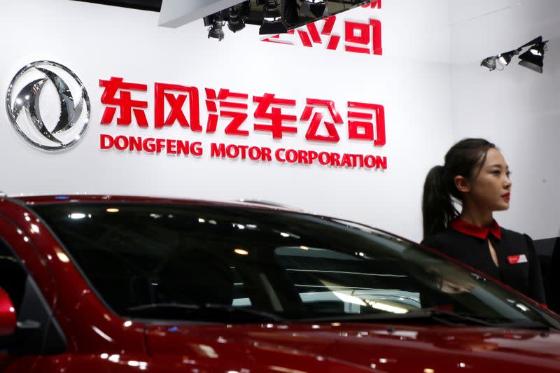 A hostess poses next to Dongfeng Motor Corp A9 sedan at the Auto China 2016 auto show in Beijing