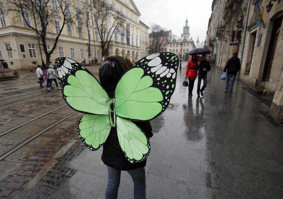 In this photo taken Saturday, Feb. 22, 2014, people walk in downtown Lviv, western Ukraine. If Ukraine looks neatly delineated on maps, its often-bloody history is a tangle of invasions and occupations, peoples and religions. It is a place that has been struggling for centuries to define itself. And now it finds itself so sharply divided _ between allegiance to Russia on one side of the country and loyalty to the West on the other _ that it often seems more like two countries than one. (AP Photo/Darko Vojinovic)