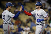 Texas Rangers' Jonah Heim, right, gets congratulations from Eli White after hitting a two-run home run against the Los Angeles Dodgers during the fourth inning of a baseball game in Los Angeles, Saturday, June 12, 2021. (AP Photo/Alex Gallardo)