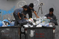 FILE - Boys scavenge in a dumpster for valuables and metal cans that can be resold, in Beirut, Lebanon, June 17, 2021. As Lebanon faces one of the world’s worst financial crises in modern history, now even its trash has become a commodity fought over in the street. (AP Photo/Hussein Malla, File)