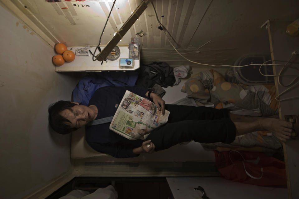 In this Thursday, March 28, 2017 photo, a resident who only gave his surname Yeung, takes rest in his "coffin home" in Hong Kong. In wealthy Hong Kong, there's a dark side to a housing boom, with hundreds of thousands of people forced to live in partitioned shoebox apartments, "coffin homes" and other "inadequate housing.(AP Photo/Kin Cheung)
