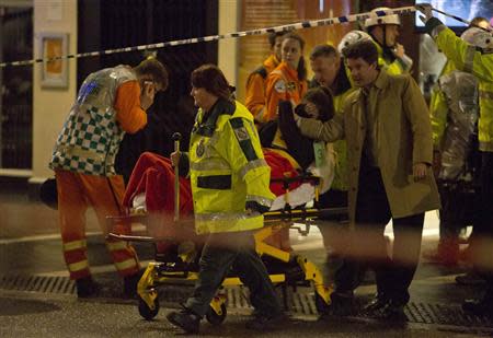 People receive medical attention after part of the ceiling at the Apollo Theatre on Shaftesbury Avenue collapsed in central London December 19, 2013. REUTERS/Neil Hall