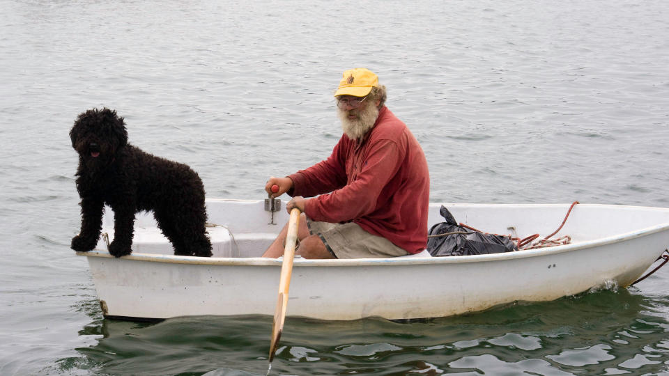 Sailor with his dog in rowing boat