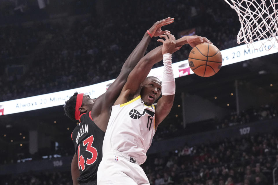 Utah Jazz guard Kris Dunn (11) goes to the net against Toronto Raptors forward Pascal Siakam (43) during first-half NBA basketball game action in Toronto, Saturday, Dec. 23, 2023. (Chris Young/The Canadian Press via AP)