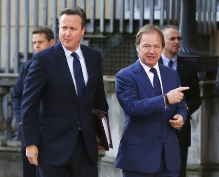Prime Minister David Cameron (L) is met by Britain's Foreign Office minister Hugo Swire as he arrives at a summit on corruption at Lancaster House in central London, Britain, May 12, 2016. REUTERS/Paul Hackett