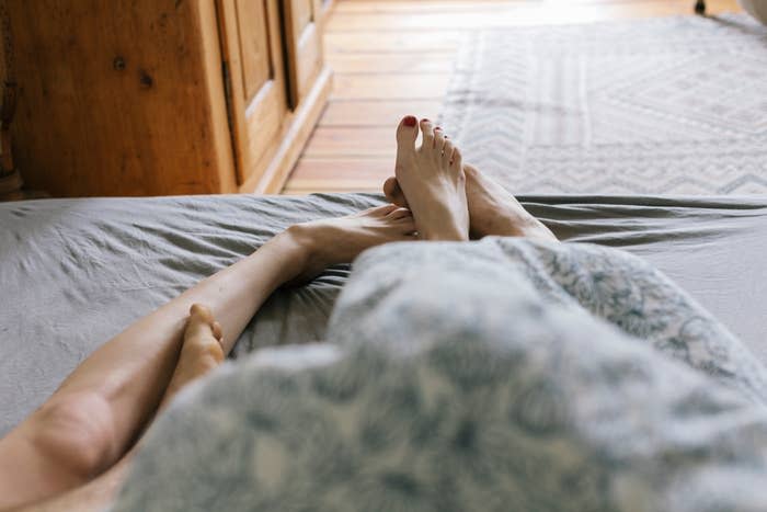 Two people are in bed together with their limbs tangled up