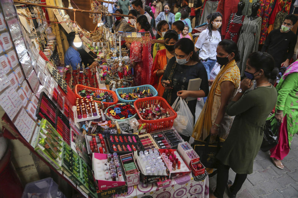Indians crowd a market area ahead of Hindu festivals in Jammu, India, Sunday, Oct.25, 2020. Weeks after India fully opened up from a harsh lockdown and began to modestly turn a corner by cutting new coronavirus infections by near half, a Hindu festival season is raising fears that a fresh surge could spoil the hard-won gains. (AP Photo/Channi Anand)