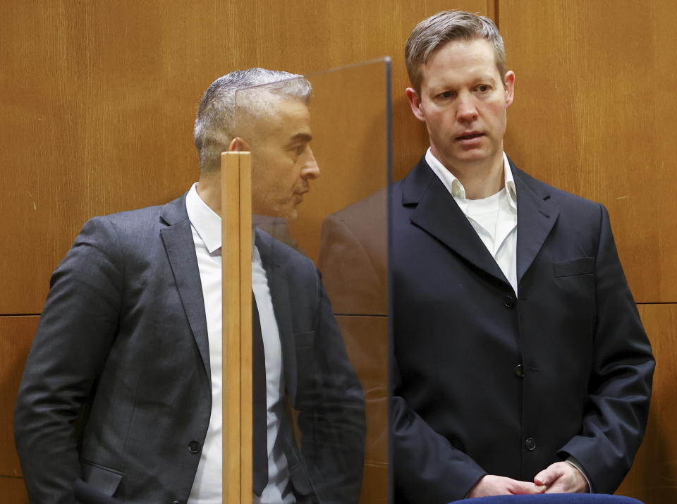 Main defendant Stephan Ernst, right, talks to his his lawyer Mustafa Kaplan, left, in the courtroom at the higher regional court in Frankfurt, Germany, Thursday, Jan. 28, 2021. The German court has convicted the 47-year-old far-right extremist Stephan Ernst of the murder of Walter Luebcke, a regional politician, in a brazen killing that shocked the country, and sentenced to life in prison. (Kai Pfaffenbach/Pool Photo via AP)