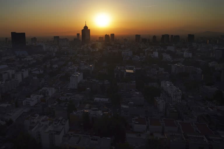 El sol sale detrás del World Trade Center, en el centro a la izquierda, en una mañana llena de smog en la Ciudad de México, el 31 de marzo de 2022.