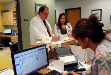 Ventzislav Vanguelov (L), an obstetrics and gynecology doctor, gives instructions to physician's assistant Celena Pollock (C) at Nuestra Clinica de Valle women's clinic in San Juan, Texas, September 22, 2015. REUTERS/Delcia Lopez