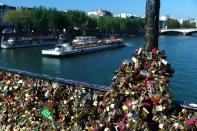 This April 9, 2014 photo shows love locks fixed on the Pont des Arts in Paris. A recent fad among travellers of hitching padlocks on bridges and at tourist attractions worldwide to symbolically immortalize their amorous attraction has swept up this reputed City of Love more than most. Now, two American-born women who live in Paris say they've had enough, launching a petition drive to try to get mostly laissez-faire city officials to step in and do something about what they call an unbearable eyesore in a majestic municipality. (AP Photo/Thibault Camus)