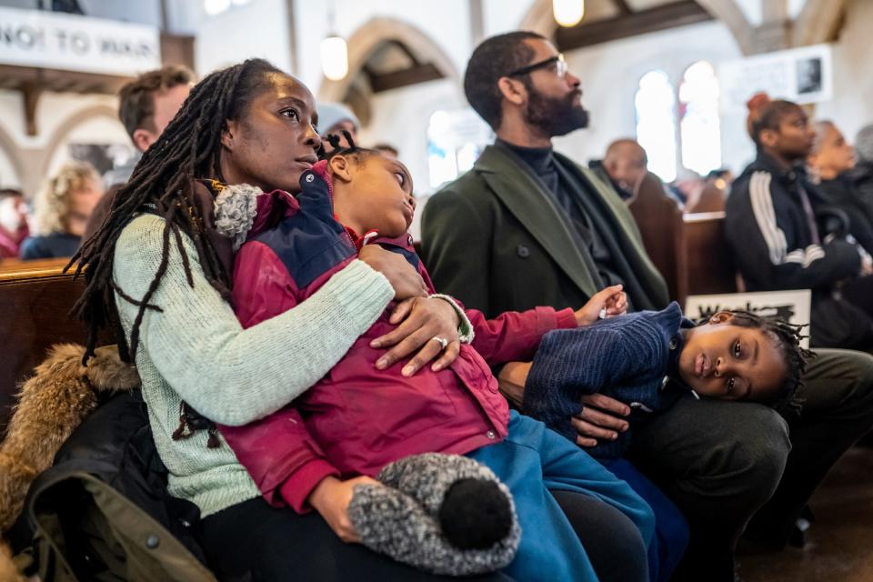 Detroit Justice Center executive director Nancy Parker holds her daughter, Nina Parker, as her daughter, Anuoluwa Parker, rests her head on her husband, Leon Parker's, lap as they listen to a speaker during the 21st Detroit Martin Luther King Jr. Day rally and march at St. Matthew's & St. Joseph's Episcopal Church in Detroit on Monday, Jan. 15, 2024.