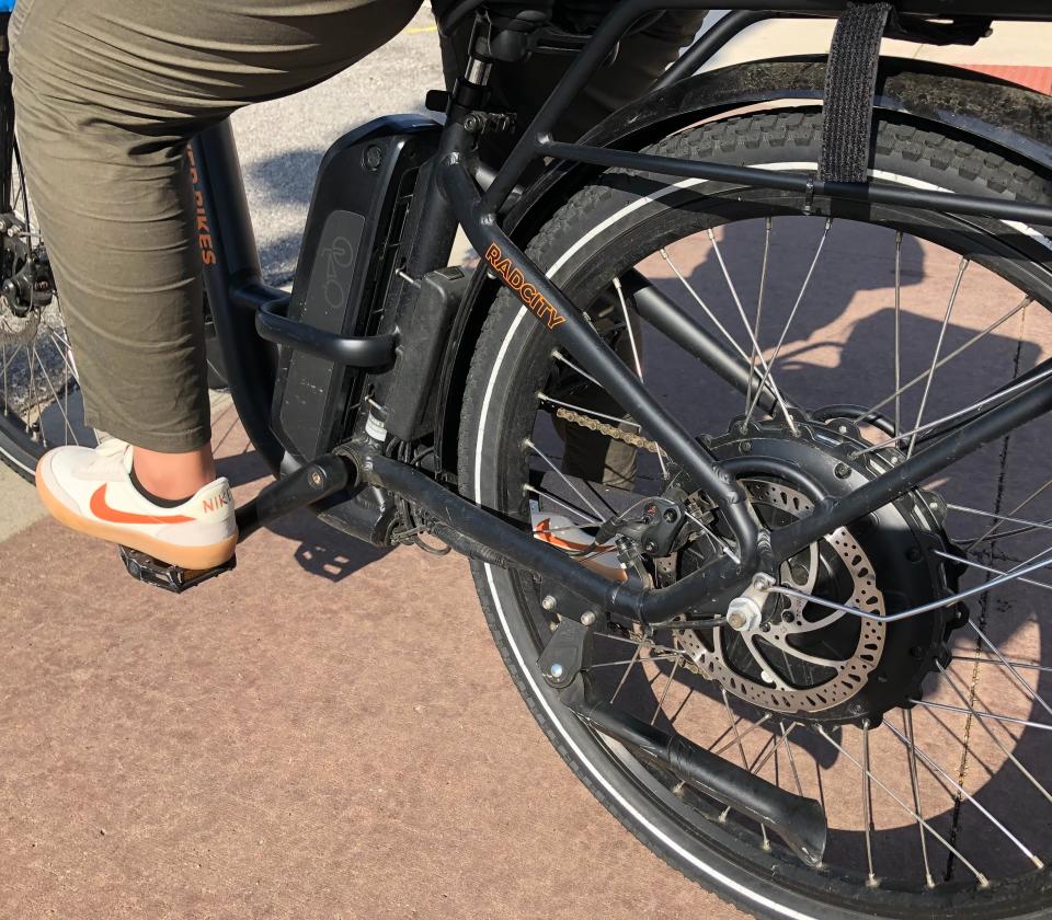 The battery on Norah Alwalan's electric-assist bike is fixed on the bike between her leg and the back wheel, seen here on her commute to work in downtown South Bend.