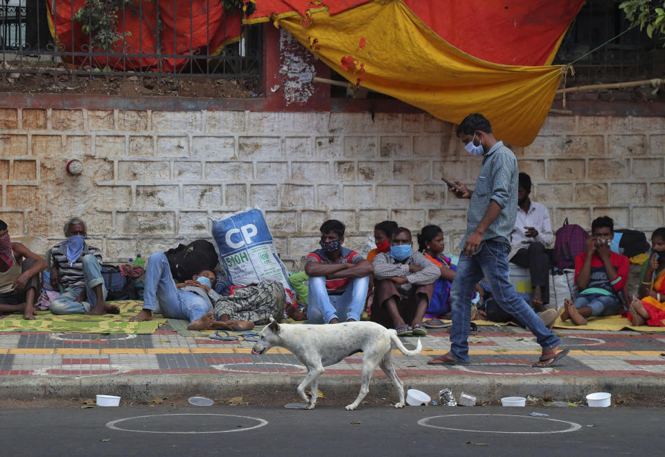 FILE - In this Tuesday, June 9, 2020, file photo, migrant workers from other states rest on a pavement as they wait for trains to their home states in Hyderabad, India. In just three weeks in June and July, India's confirmed cases shot up from the world’s sixth to the third-worst hit country by the coronavirus pandemic, according to a tally by Johns Hopkins University. India's fragile health system was bolstered during stringent monthslong lockdown but could still be overwhelmed by an exponential rise in infections. (AP Photo/Mahesh Kumar A., File)