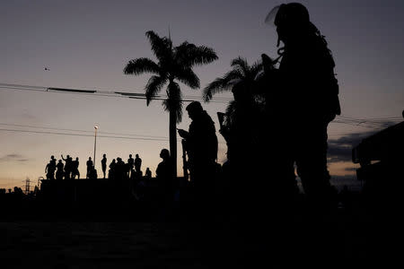 Demonstrators gather atop a truck as Brazil's Army soldiers patrol outside a fuel distribution center as truckers attend a protest against high diesel fuel prices in Duque de Caxias near Rio de Janeiro, Brazil May 27, 2018. REUTERS/Ricardo Moraes