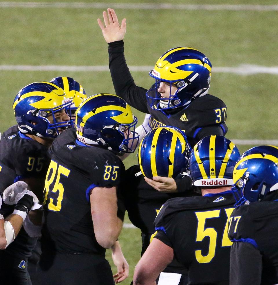 Delaware placekicker Alex Schmoke is mobbed by the kick team members after his 23-yard field goal put the Hens on top with 1:37 remaining in the Blue Hens' 36-34 comeback win against Lafayette in the opening round of the NCAA FCS playoffs Saturday, Nov. 25, 2023 at Delaware Stadium.