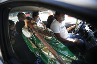 A Saint Jude statue is transported in the passenger seat of a car during the annual pilgrimage honoring Jude, the patron saint of lost causes, in Mexico City, Wednesday, Oct. 28, 2020. Thousands of Mexicans did not miss this year to mark St. Jude's feast day, but the pandemic caused Masses to be canceled and the rivers of people of other years outside the San Hipolito Catholic church were replaced by orderly lines of masked worshipers waiting their turn for a blessing. (AP Photo/Marco Ugarte)