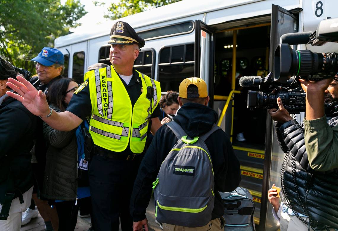 Edgartown Chief of Police Bruce R. McNamee helps Venezuelan migrants onto a bus at St. Andrews Episcopal Church on Friday, Sept. 16, 2022, in Edgartown, Mass., on the island of Martha’s Vineyard. A group of 48 migrants was flown to the island from Texas earlier this week. They are being transferred to a military base in Cape Cod.