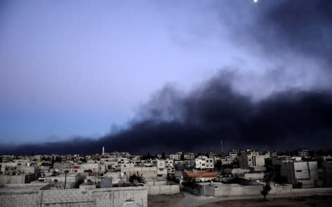 Smoke rises into the sky from what activists said was Free Syrian Army fighters destroying a tank that belonged to forces loyal to Syria's President Bashar al-Assad in the Qaboun area, Eastern Ghouta - Credit: Reuters