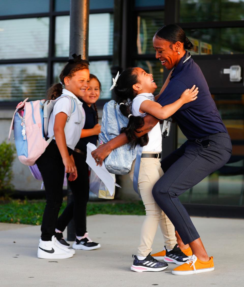 Student Itzell Gonzales gets a hug from staffer Racaiya Darden outside Shaffner Traditional Elementary on the first day of classes Wednesday morning, Aug. 9, 2023. 