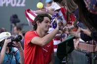 Taylor Fritz holds signs autographs after defeating Rafael Nadal, of Spain, in the men's singles finals at the BNP Paribas Open tennis tournament Sunday, March 20, 2022, in Indian Wells, Calif. Fritz won 6-3, 7-6. (AP Photo/Mark J. Terrill)