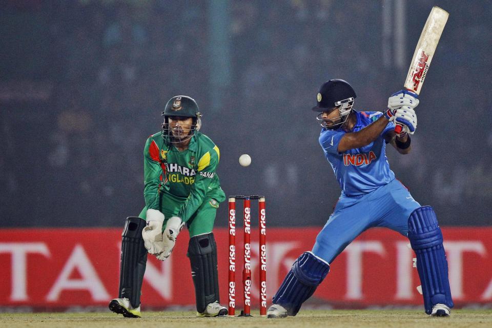 India’s Virat Kohli, right, plays a shot as Bangladesh’s wicketkeeper Anamul Haque watches during the Asia Cup one-day international cricket tournament between them in Fatullah, near Dhaka, Bangladesh, Wednesday, Feb. 26, 2014. (AP Photo/A.M. Ahad)