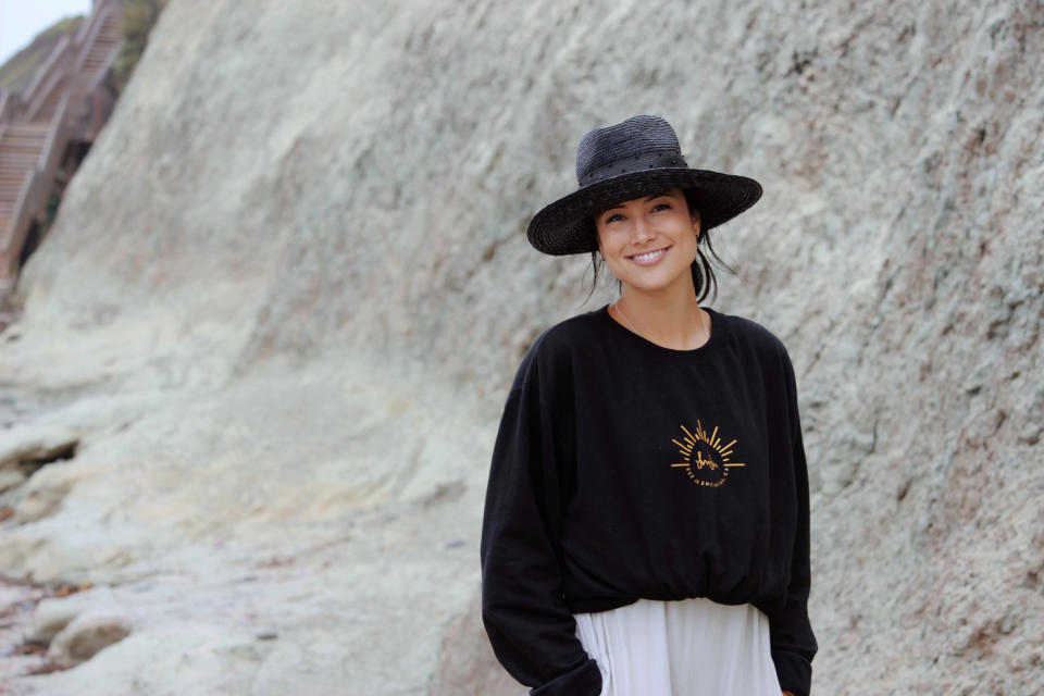 Nebraska volleyball player Lexi Sun is seen wearing a sweatshirt with her name on it in Encinitas, Ca., on June 19, 2021. Sun wanted her deal with volleyball apparel company Ren Athletics to allow her personality and style to shine through in the launch of her clothing line — a black sweatshirt with her name and a golden outline of the sun's rays. It quickly sold out. (Natalie Hagglund via AP)