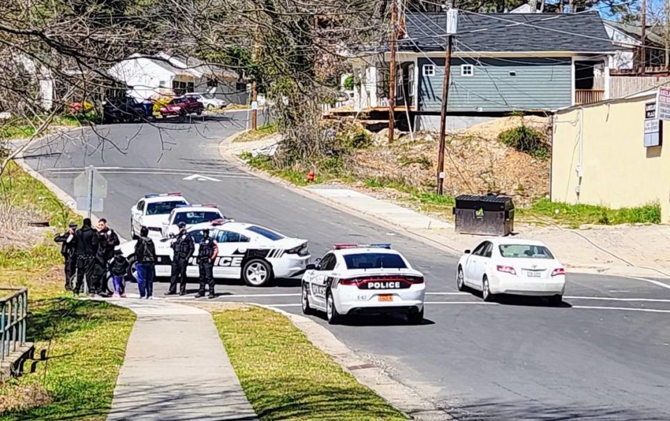 Four police officers questions two young men in McDougald Terrace on March 21, 2022.