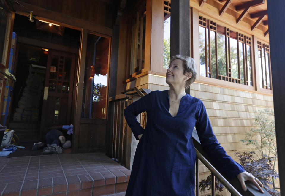 In this photo taken Thursday, June 20, 2013 Alice Waters looks over the new front entrance to her Chez Panisse restaurant in Berkeley, Calif. After a fire in March shut the doors to the famous gourmet restaurant, the eatery is preparing to reopen June 24. (AP Photo/Eric Risberg)