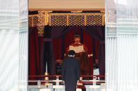 Japan's Emperor Naruhito speaks as Prime Minister Shinzo Abe bows during a ceremony to proclaim his enthronement to the world, called Sokuirei-Seiden-no-gi, at the Imperial Palace in Tokyo, Japan, Tuesday, Oct. 22, 2019. (Issei Kato/Pool Photo via AP)