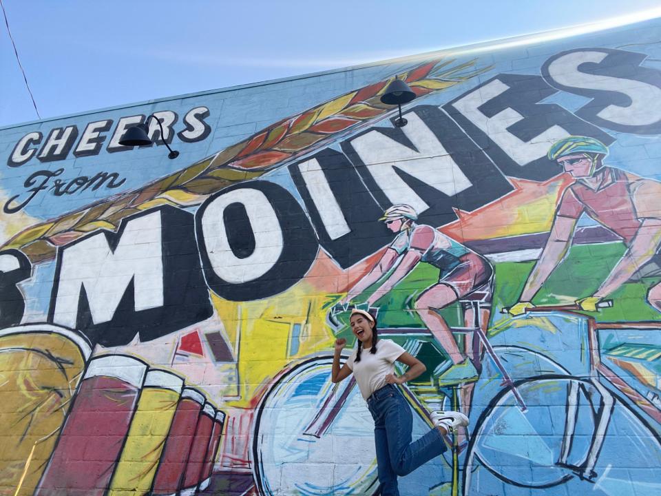Des Moines Register reporter Paris Barraza takes a selfie in front of the "Cheers from Des Moines" mural in Des Moines on Sept. 9, 2023.