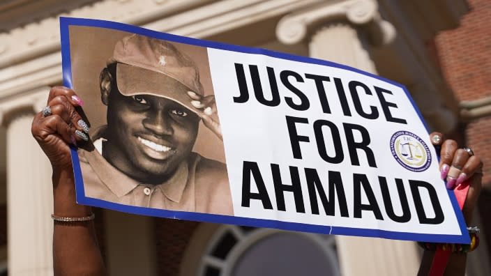 A demonstrator holds a sign at the Glynn County Courthouse in Oct. 2021 as jury selection began in the trial of the shooting death of Ahmaud Arbery in Brunswick, Georgia. (Photo: Sean Rayford/Getty Images)
