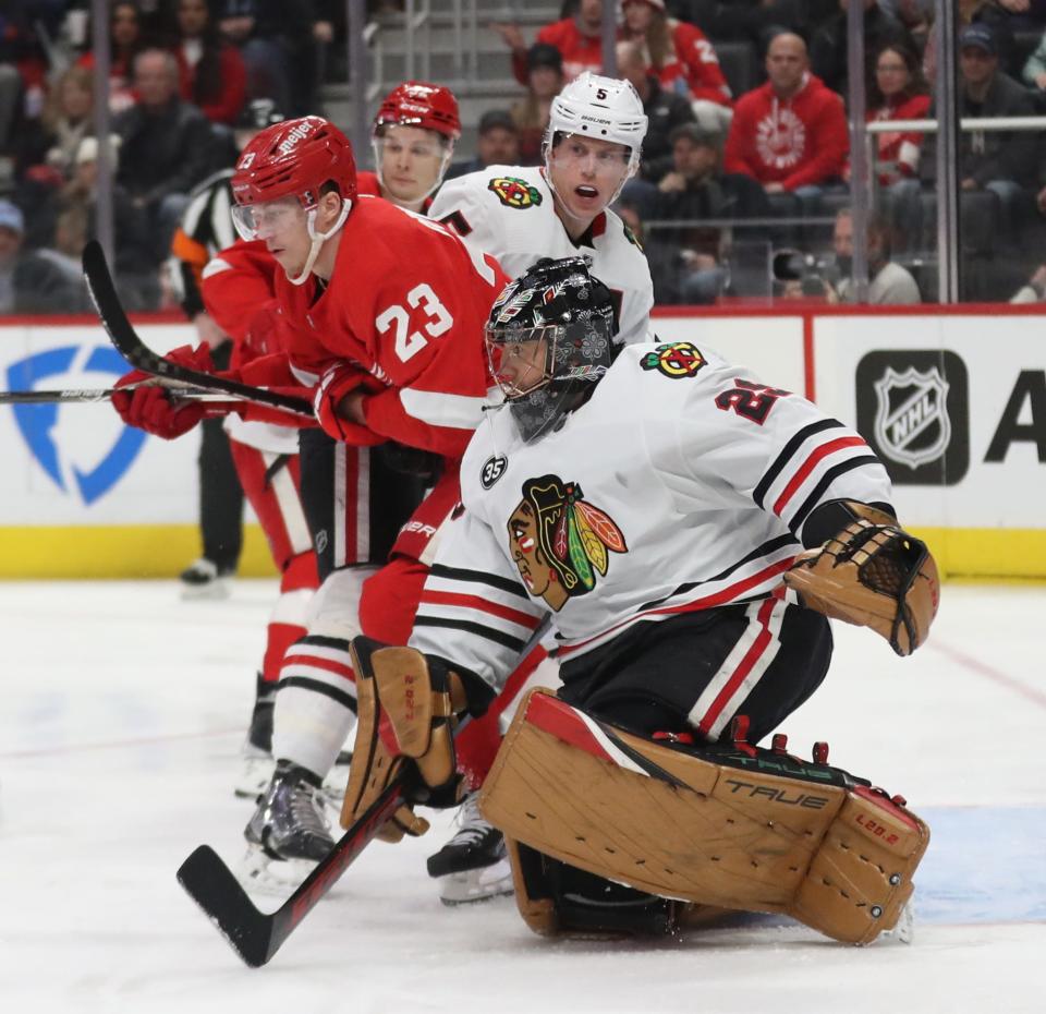 Detroit Red Wings left wing Lucas Raymond (23) is checked by Chicago Blackhawks goaltender Marc-Andre Fleury (29) during first period action Wednesday, Jan. 26, 2022 at Little Caesars Arena.