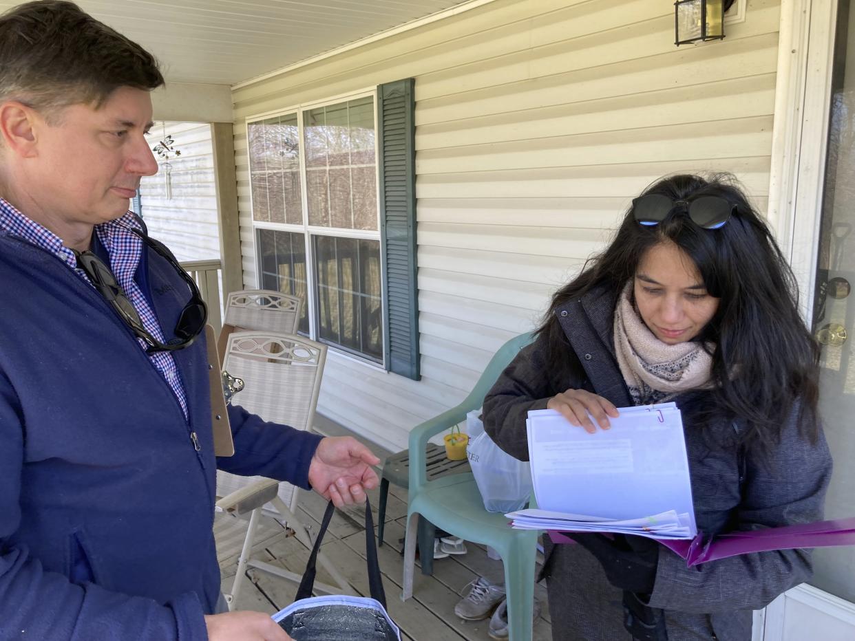 Ted Larson, left, of the U.S. Agency for Toxic Substances and Disease Registry, and Vidisha Parasram of the National Institute for Occupational Safety and Health visiting a house, Feb. 26, 2023, in Darlington Township, Pa. The community is across the state line from East Palestine, Ohio, where a Feb. 3 train derailment has raised fears of air and water contamination. Federal and state officials have been going door to door inviting residents to take a health assessment. (AP Photo/John Flesher)