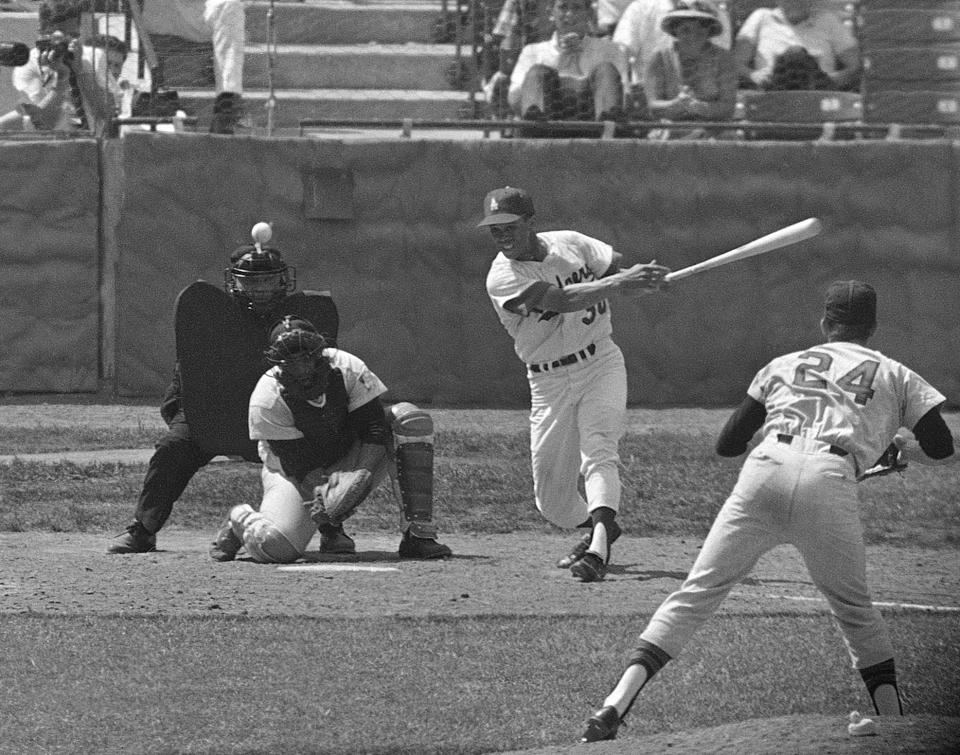 FILE - National League batter Maury Wills hits a single to right to drive in the winning run in the 10th inning of the baseball All-Star game in St. Louis, July 12, 1966. American League' pitcher Pete Richert. catcher Earl Battey, and umpire Jim Honochick are also shown. National League won 2-1. Maury Wills, who helped the Los Angeles Dodgers win three World Series titles with his base-stealing prowess, has died. The team says Wills died Monday night, Sept. 19, 2022, in Sedona, Ariz. He was 89. (AP Photo/File)