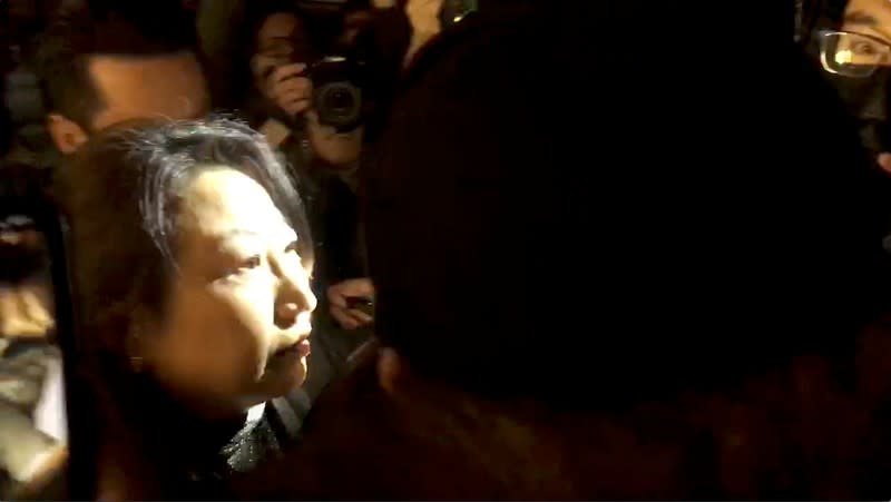 Hong Kong Justice Secretary Teresa Cheng walks as protesters surround her in London, Britain