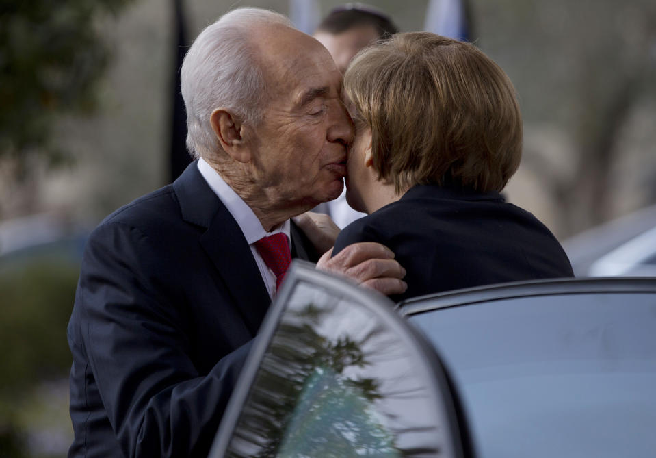 FILE - In this file photo taken Tuesday, Feb. 25, 2014, Israel's President Shimon Peres kisses German Chancellor Angela Merkel as she arrives to receive the Presidential Medal ceremony at the President's residence in Jerusalem. Among those vying to become Israel's next president are a former defense minister, a former foreign minister, a former finance minister, a respected long-serving lawmaker and a Nobel Prize winner. Amazingly, the man they all seek to replace has held all of those titles and more during a legendary 65-year political career. (AP Photo/Ariel Schalit, File)